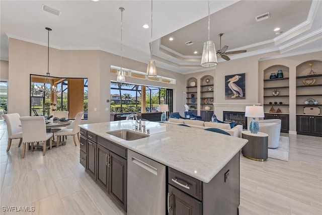 kitchen featuring a sink, a ceiling fan, built in shelves, stainless steel dishwasher, and open floor plan