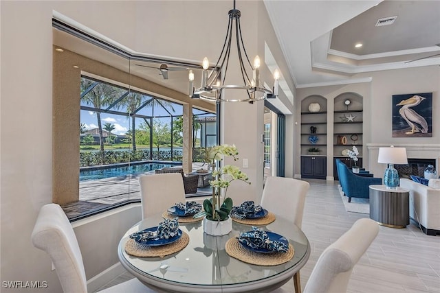 dining room featuring a sunroom, ornamental molding, a chandelier, visible vents, and built in features
