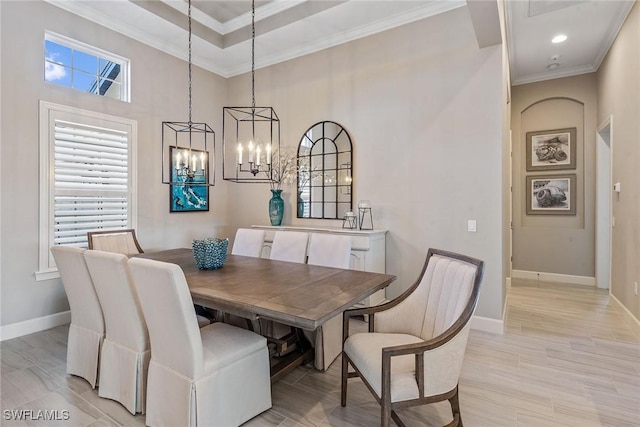 dining space with baseboards, light wood-type flooring, a chandelier, and crown molding