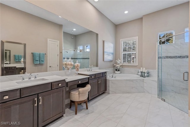 bathroom featuring a garden tub, vanity, and a stall shower