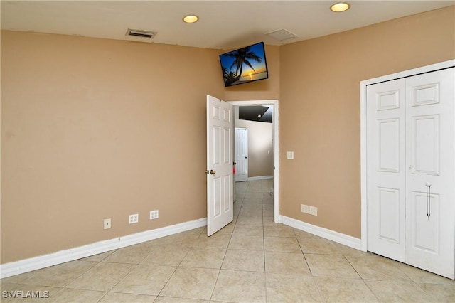 unfurnished bedroom featuring light tile patterned floors, recessed lighting, visible vents, baseboards, and a closet