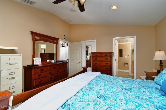 bedroom featuring ceiling fan, visible vents, vaulted ceiling, and ensuite bathroom