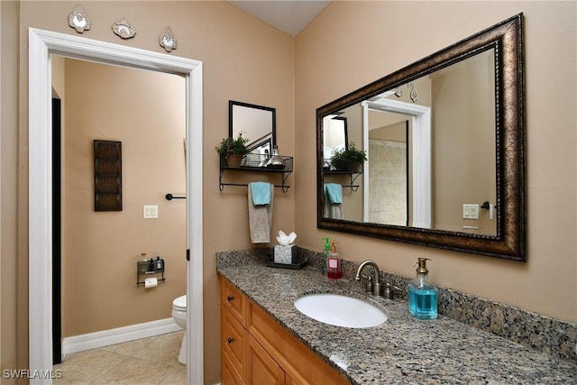 bathroom with tile patterned flooring, baseboards, vanity, and toilet