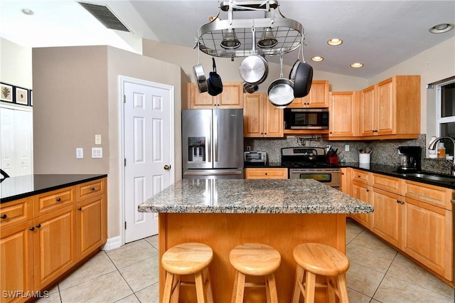 kitchen with light tile patterned floors, stainless steel appliances, tasteful backsplash, visible vents, and a sink