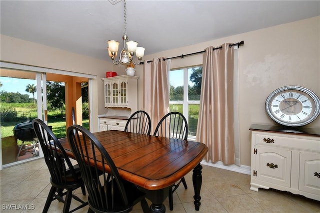 dining space with light tile patterned floors and a chandelier