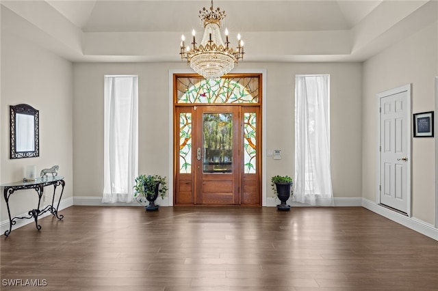 foyer entrance featuring vaulted ceiling, dark hardwood / wood-style flooring, and an inviting chandelier