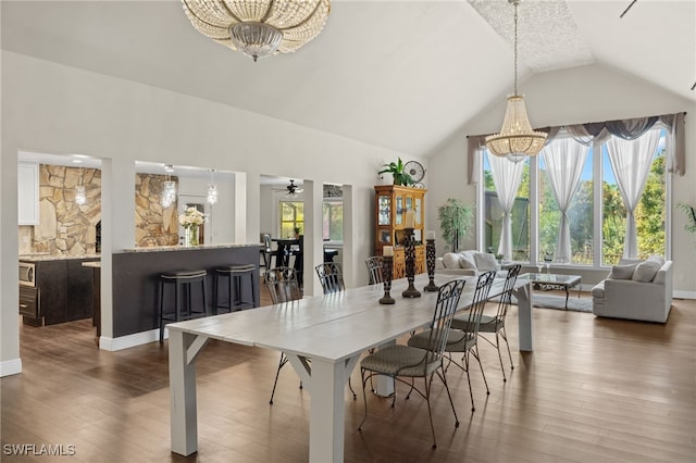 dining area featuring a healthy amount of sunlight, dark wood-type flooring, and ceiling fan with notable chandelier