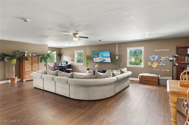 living room featuring dark wood-type flooring and ceiling fan