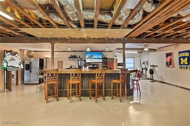 bar featuring stainless steel refrigerator with ice dispenser and ceiling fan