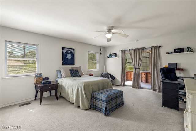 carpeted bedroom with multiple windows and ceiling fan