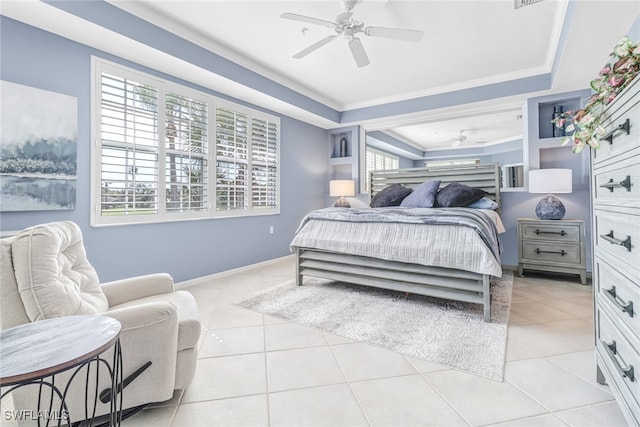 tiled bedroom with crown molding, multiple windows, a tray ceiling, and ceiling fan