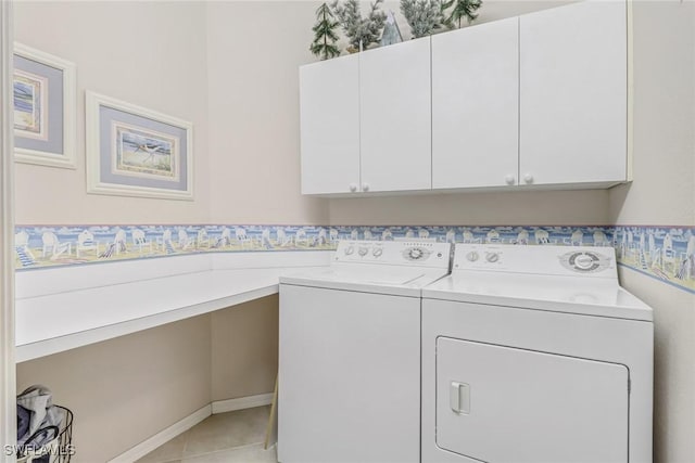 clothes washing area with light tile patterned floors, washer and dryer, and cabinet space
