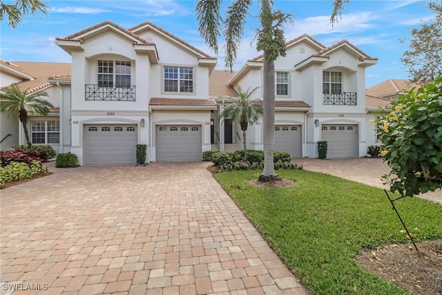 mediterranean / spanish-style house with a front yard and a garage