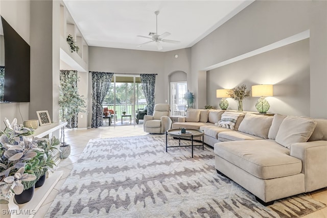 living room with light tile patterned flooring, a towering ceiling, and ceiling fan