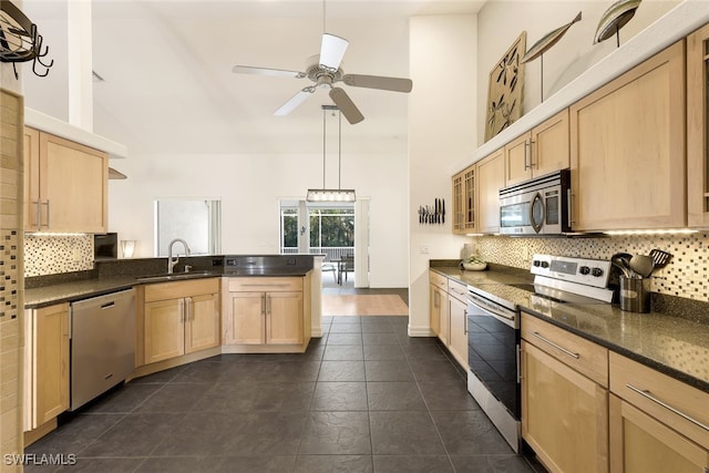 kitchen with light brown cabinetry, sink, appliances with stainless steel finishes, and high vaulted ceiling