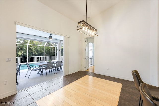 dining room with dark hardwood / wood-style floors, high vaulted ceiling, and ceiling fan