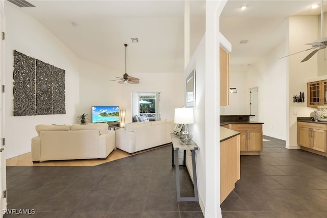 living room with high vaulted ceiling, dark tile patterned floors, and ceiling fan