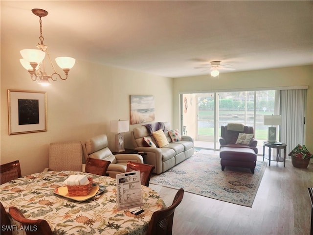 living room with hardwood / wood-style flooring and ceiling fan with notable chandelier