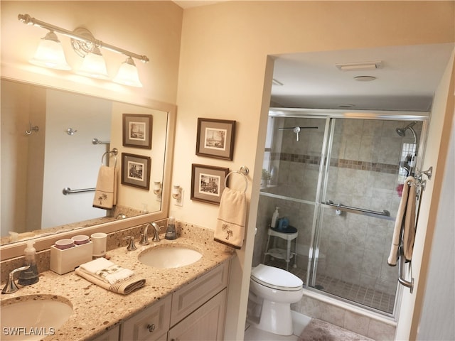 bathroom with toilet, tile patterned flooring, vanity, and a shower with door