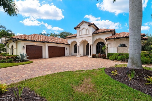 mediterranean / spanish-style house with a front lawn and a garage