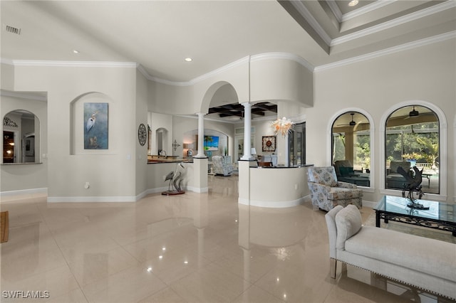 living room with a towering ceiling, ornamental molding, light tile patterned floors, and decorative columns