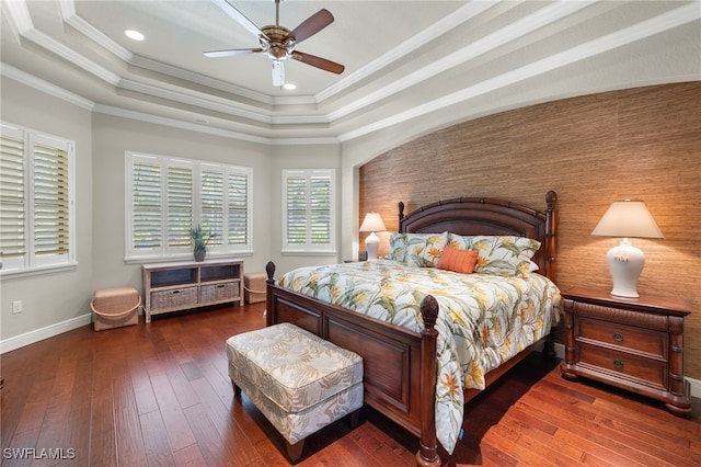 bedroom with dark hardwood / wood-style flooring, crown molding, a tray ceiling, and ceiling fan