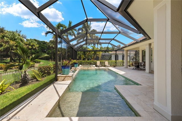 view of pool with a patio area and glass enclosure