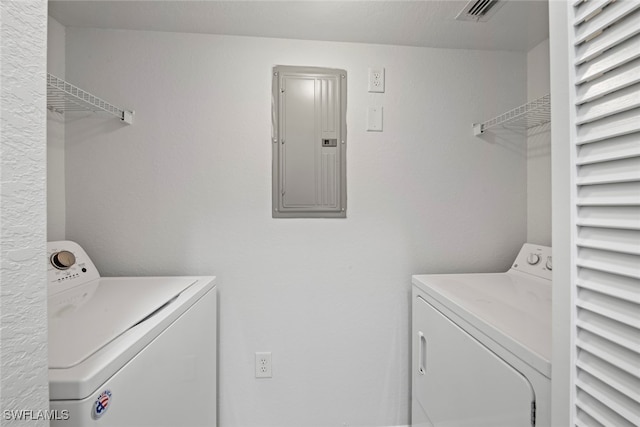 laundry area featuring electric panel and washing machine and clothes dryer