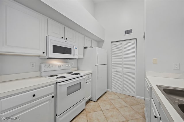 kitchen with sink, white cabinets, white appliances, and light tile patterned floors