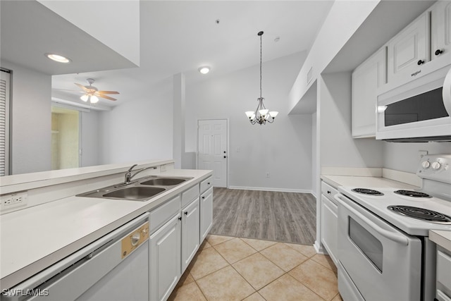 kitchen featuring white appliances, sink, white cabinetry, pendant lighting, and light tile patterned floors