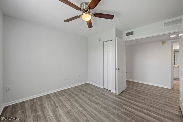 unfurnished bedroom with wood-type flooring, a closet, and ceiling fan