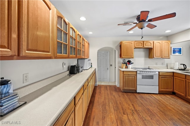 kitchen featuring sink, wood-type flooring, white appliances, and ceiling fan