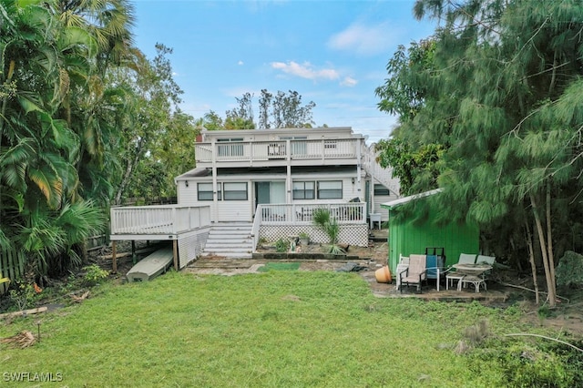 rear view of house with a yard and a wooden deck