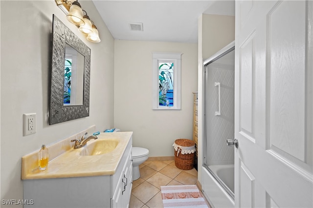 full bathroom featuring vanity, toilet, combined bath / shower with glass door, and tile patterned flooring