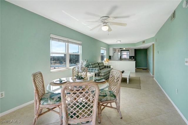 dining space with ceiling fan and light tile patterned floors