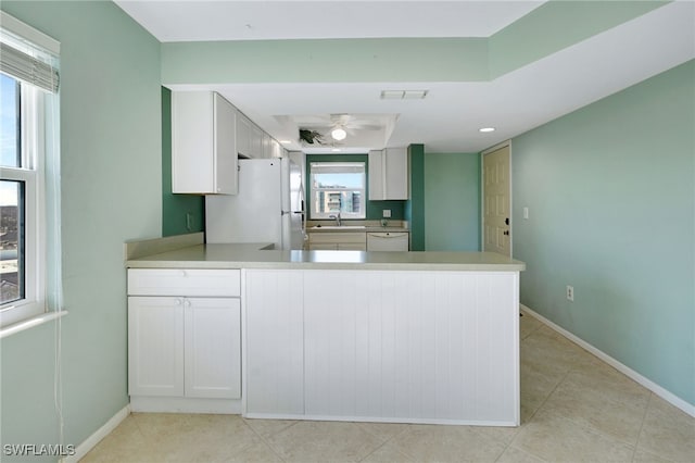 kitchen featuring white appliances, white cabinetry, a wealth of natural light, and kitchen peninsula