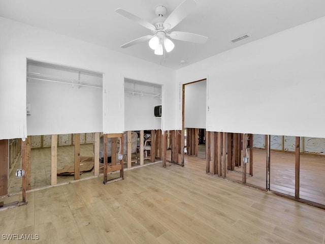 bedroom featuring light hardwood / wood-style flooring and two closets