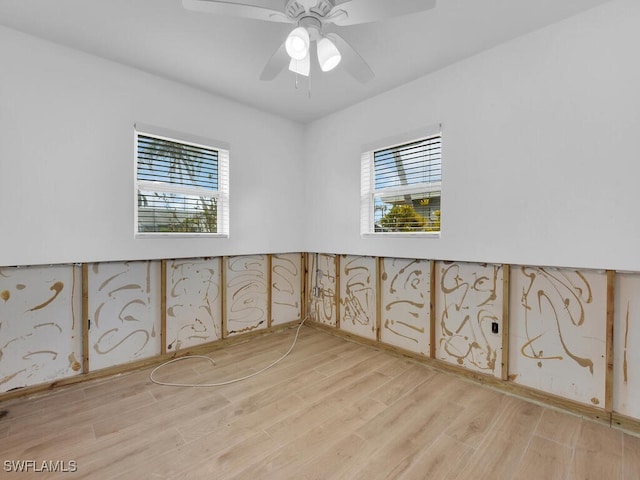 unfurnished room with light wood-type flooring, plenty of natural light, and ceiling fan