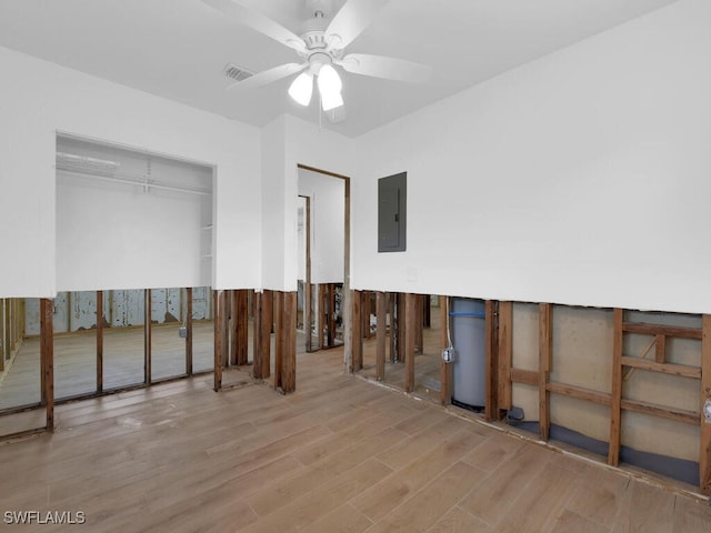 interior space with electric panel, light wood-type flooring, a closet, and ceiling fan