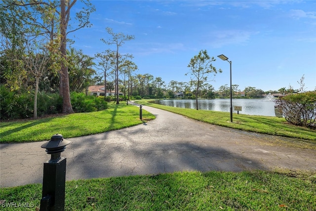 view of community with a yard and a water view