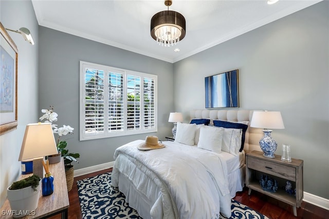 bedroom with an inviting chandelier, dark hardwood / wood-style flooring, and ornamental molding