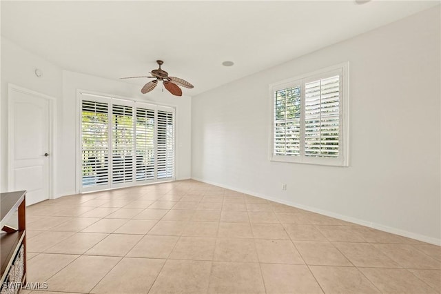 spare room with ceiling fan and light tile patterned floors