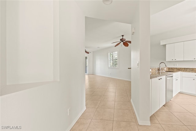 kitchen featuring ceiling fan, white cabinets, light tile patterned floors, and stainless steel dishwasher