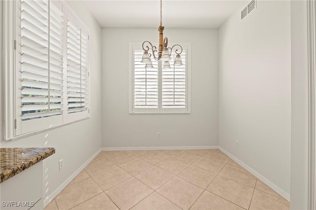 unfurnished dining area featuring light tile patterned floors and a notable chandelier