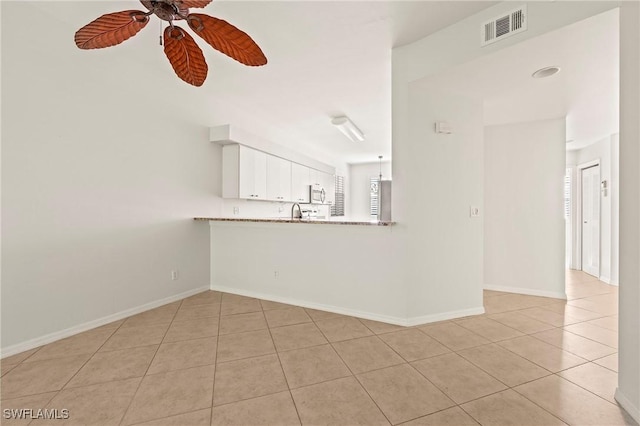 unfurnished living room with ceiling fan, sink, and light tile patterned flooring