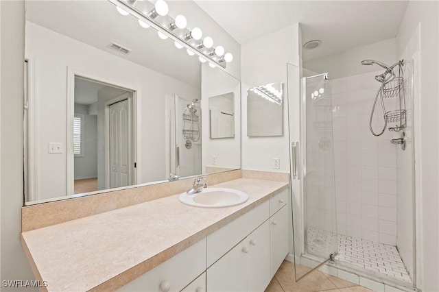 bathroom with tile patterned floors, a shower with door, and vanity