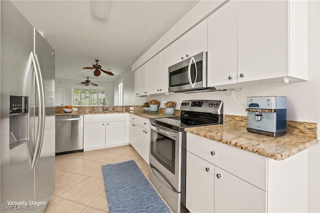 kitchen with white cabinetry, stainless steel appliances, sink, ceiling fan, and light tile patterned floors