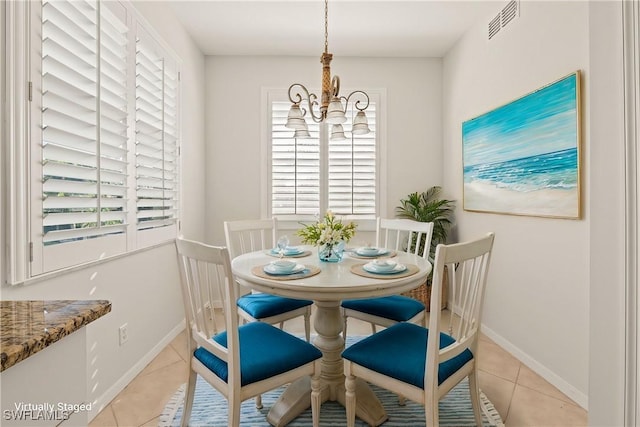 dining area featuring light tile patterned floors and an inviting chandelier