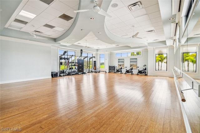 interior space with light wood-type flooring, a paneled ceiling, and ceiling fan