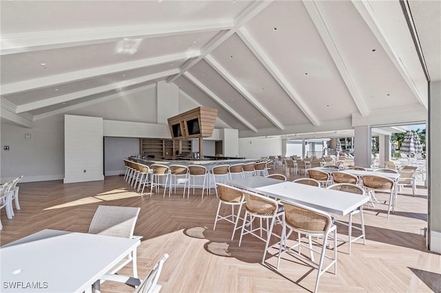 dining area with vaulted ceiling with beams and light parquet flooring